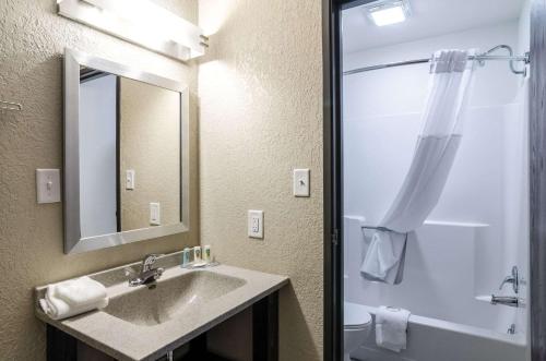 a bathroom with a sink and a shower with a mirror at Quality Inn Great Bend in Great Bend