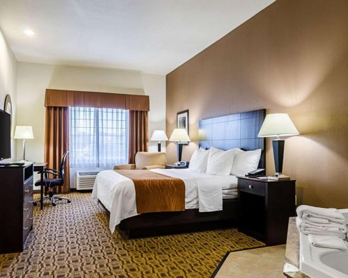 ローレンスにあるComfort Inn & Suites Lawrence - University Areaの大きなベッドとバスルームが備わるホテルルームです。