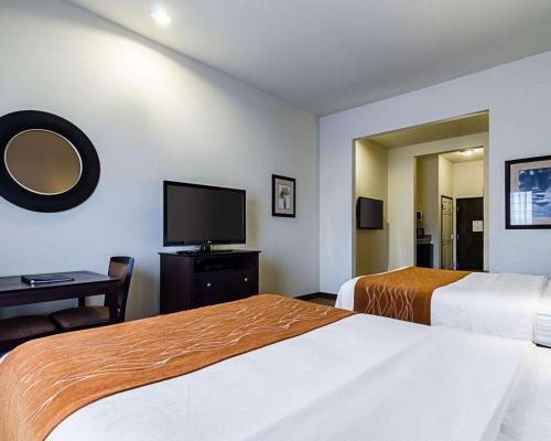 a hotel room with two beds and a flat screen tv at Comfort Inn & Suites Lawrence - University Area in Lawrence