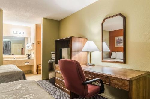 a hotel room with a desk and a mirror at Executive Inn Dodge City, KS in Dodge City