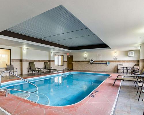 a large pool in a hotel with tables and chairs at Comfort Inn & Suites Lawrence - University Area in Lawrence