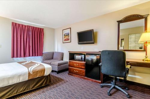 a hotel room with a bed and a desk and a computer at Quality Inn South in Wichita