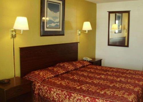 een hotelkamer met een bed en twee lampen bij Rodeway Inn in Goddard
