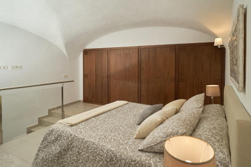 een slaapkamer met een groot bed met een houten hoofdeinde bij Apartamento Turístico Centro Monumental -- Caceres in Cáceres