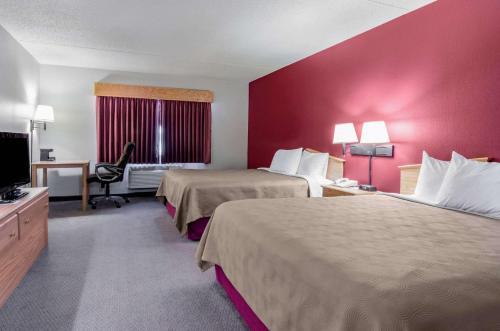 ein Hotelzimmer mit 2 Betten und einem Flachbild-TV in der Unterkunft Rodeway Inn in Hesston