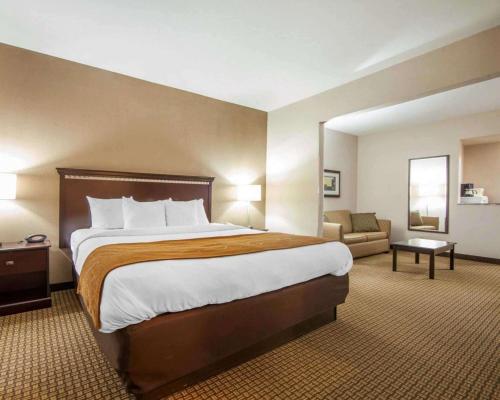 a hotel room with a large bed and a couch at Comfort Suites in London