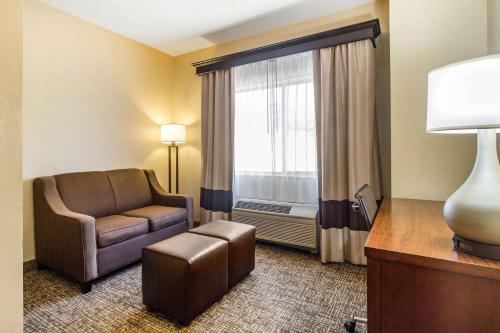 a hotel room with a chair and a window at Quality Suites in Corbin