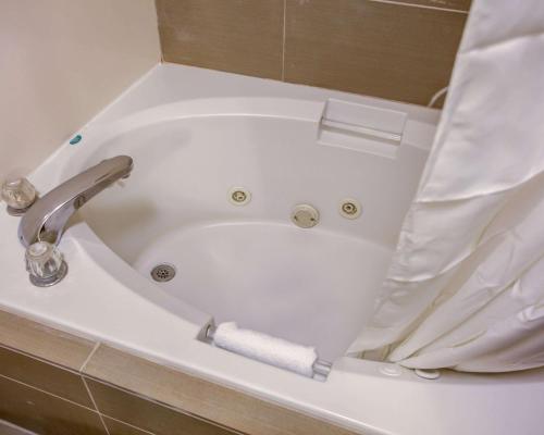 a bathtub with a roll of toilet paper in it at Comfort Suites Georgetown in Georgetown