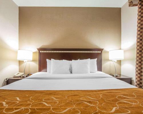 a bed in a hotel room with two lamps at Comfort Suites London South in London