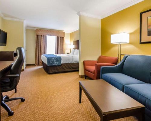 a hotel room with a bed and a couch and chair at Comfort Suites in Elizabethtown