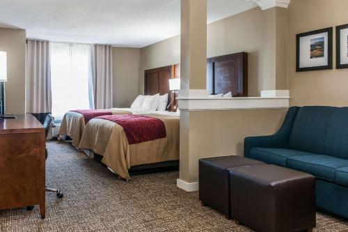 a hotel room with a bed and a blue couch at Comfort Inn & Suites Mount Sterling in Mount Sterling