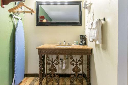 a bathroom with a wooden sink and a mirror at Quality Inn & Suites - Horse Cave in Horse Cave