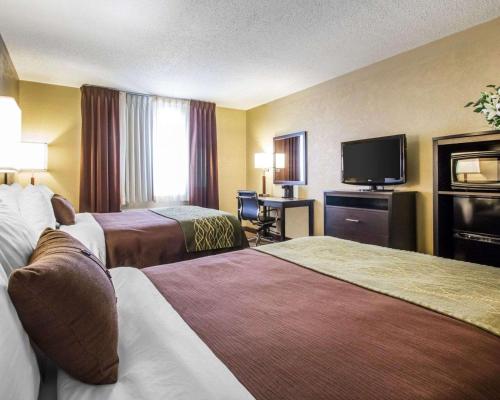 a hotel room with two beds and a flat screen tv at Quality Inn Harlan in Harlan