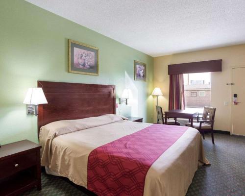 a hotel room with a large bed and a desk at Rodeway Inn & Suites in New Orleans