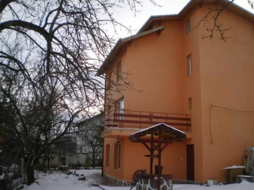 a large building with snow on top of it at Hadjibulevata Guest House in Kovachevtsi