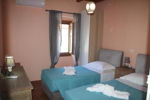 フィスカルドにあるLuxury Stone Villaのベッド2台と窓が備わるホテルルームです。