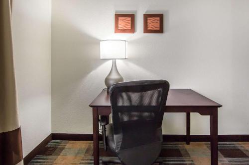 a chair sitting next to a desk with a lamp at Comfort Inn Lexington South in Nicholasville