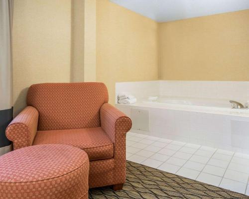 a bathroom with a chair and a bath tub at Comfort Inn in Winchester