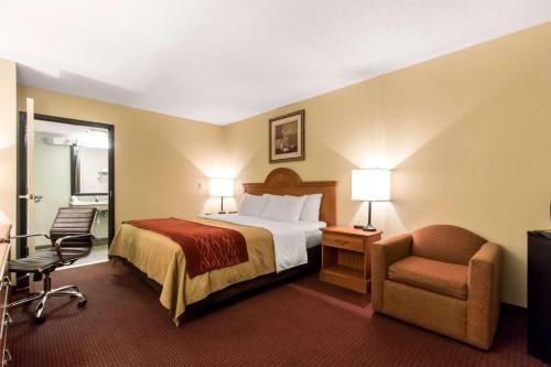 a hotel room with a bed and a chair at Quality Inn in Glasgow