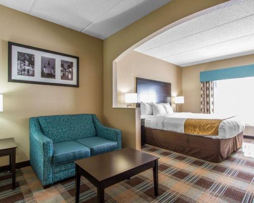 ein Hotelzimmer mit einem Bett und einem Stuhl in der Unterkunft Comfort Suites Kenner in Kenner