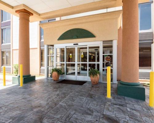 a lobby of a building with yellow poles and plants at Quality Inn Shreveport Airport in Shreveport