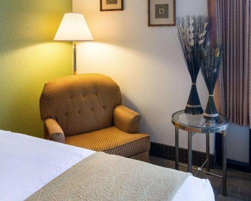 a hotel room with a chair and a lamp on a table at Quality Inn Shreveport Airport in Shreveport