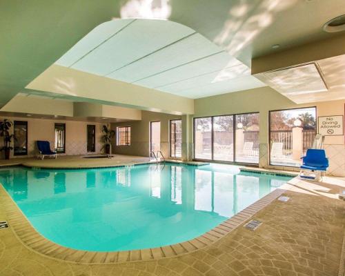 - une grande piscine d'eau bleue dans un bâtiment dans l'établissement Comfort Suites Kenner, à Kenner