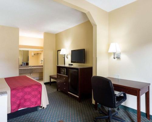 a hotel room with a bed and a desk with a computer at Rodeway Inn & Suites New Orleans Gentilly in New Orleans