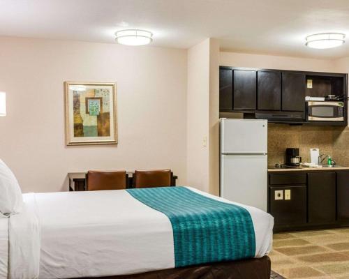 a hotel room with a bed and a kitchen at Suburban Studios Avondale in Avondale