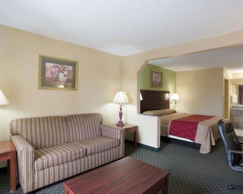 a hotel room with a bed and a couch at Rodeway Inn & Suites New Orleans Gentilly in New Orleans
