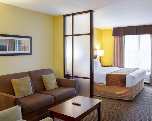 a hotel room with a bed and a couch at Comfort Suites Harvey - New Orleans West in Harvey