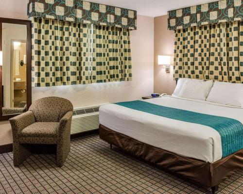 a hotel room with a bed and a chair at Suburban Studios Avondale in Avondale