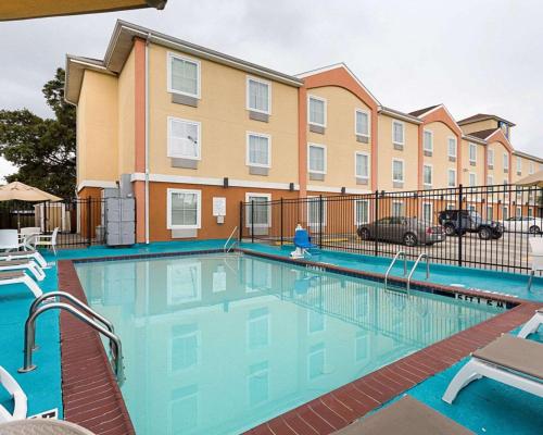 una piscina en un complejo de apartamentos con un edificio en Comfort Inn Marrero - New Orleans West, en Marrero