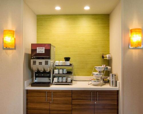 a kitchen with a yellow wall and aasteryasteryasteryasteryasteryasteryasteryastery at Comfort Suites Bossier City - Shreveport East in Bossier City