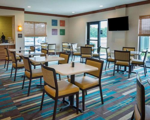 a dining room with tables and chairs and a flat screen tv at Comfort Suites Bossier City - Shreveport East in Bossier City