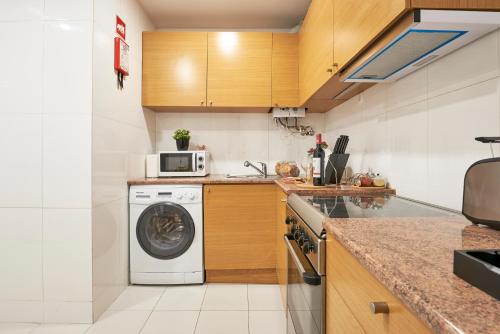 una cucina con lavatrice e forno a microonde di Casa Portuguesa Rosa a Lisbona