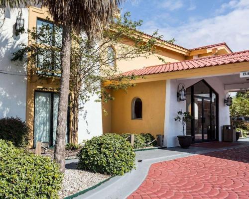 a house with a palm tree and a driveway at Sunrise Inn & Suites New Orleans in New Orleans