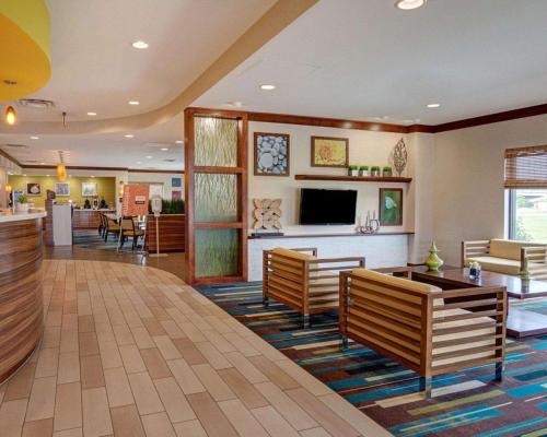 a hotel lobby with benches and a tv and a bar at Comfort Suites Bossier City - Shreveport East in Bossier City