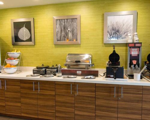 a kitchen with a counter with a stove and some pictures at Comfort Suites Bossier City - Shreveport East in Bossier City