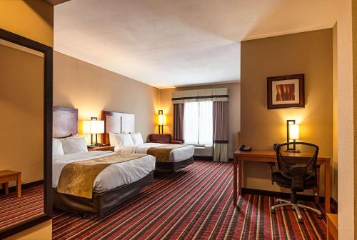 a hotel room with two beds and a desk at Comfort Suites Sulphur-Lake Charles in Sulphur