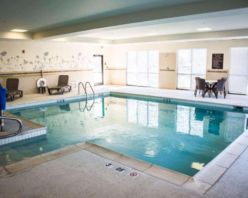 a large swimming pool with chairs and a table at Sleep Inn & Suites Medical Center in Shreveport