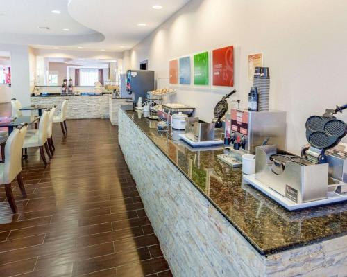 a restaurant with a counter with chairs and a counter top at Comfort Suites Mandeville - Covington in Mandeville