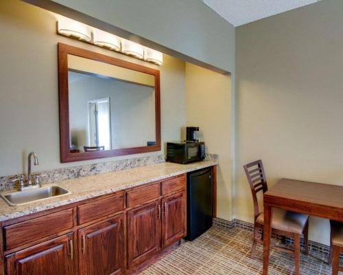 a kitchen with a sink and a mirror and a table at Comfort Inn West Monroe near Sports & Events Center in West Monroe