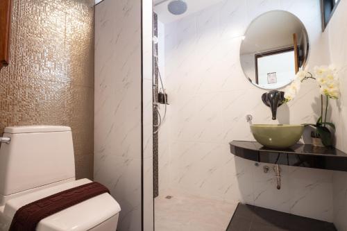 a bathroom with a toilet and a mirror at Anumat Premium Budget Hotel in Chiang Mai