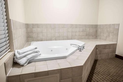 a bathroom with a bath tub with towels on it at Quality Inn & Suites Federal Way - Seattle in Federal Way