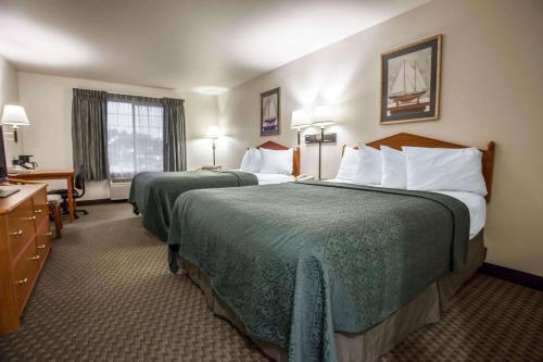 a hotel room with two beds with green sheets at Quality Inn & Suites Federal Way - Seattle in Federal Way