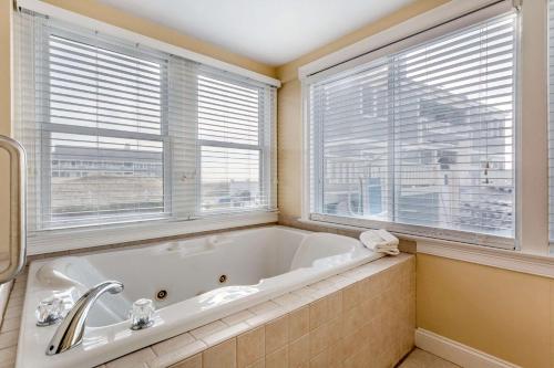 La salle de bains est pourvue d'une baignoire blanche et de 2 fenêtres. dans l'établissement Bluegreen Vacations The Breakers, an Ascend Resort, à Dennis Port