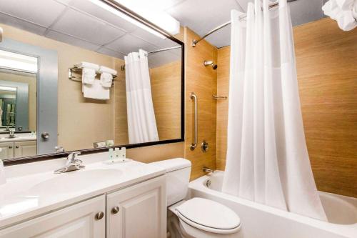 a bathroom with a sink and a toilet and a mirror at Quality Inn in West Springfield