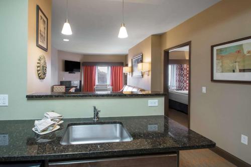 a kitchen with a sink and a living room at Bluegreen Vacations Odyssey Dells Resort in Wisconsin Dells