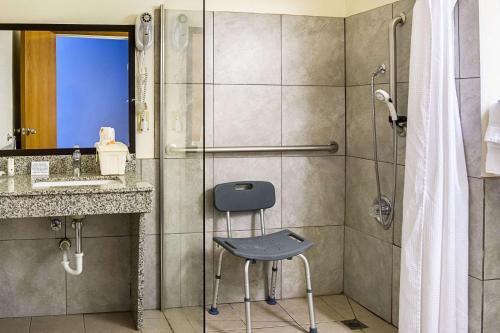 a shower with a chair in a bathroom at Quality Inn & Suites Clackamas - Portland in Clackamas